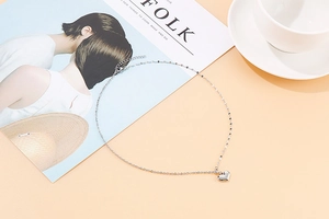Detailed top view of a silver heart pendant necklace on a creative lifestyle background
