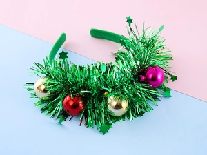 Detail of Christmas headband with green tinsel, festive colorful balls and star sequins