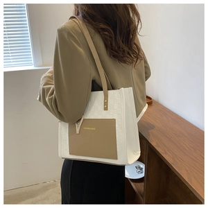Detail of checkered texture tote bag with khaki pocket and gold Fashion Bag logo