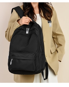 Detail view of large capacity black backpack featuring durable nylon fabric and multi-pockets