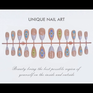 Close-up of almond-shaped press-on nails with 3D floral accents and pearl details
