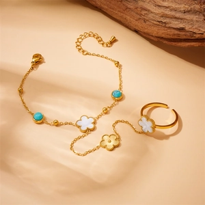 Detailed macro of gold clover bracelet with turquoise beads and mother-of-pearl inlay