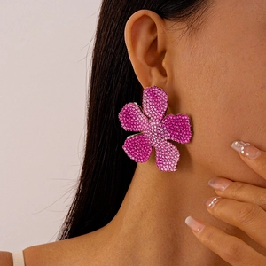 Close-up of luxury oversized flower earrings with pink gradient crystals on model