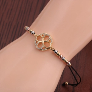 Infinity symbol gold bracelet with tri-color metal beads on an adjustable black cord