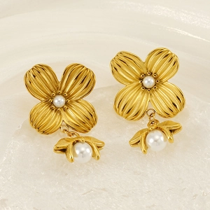 Dettaglio di orecchini a fiore in oro 18K con perle e delicati petali floreali