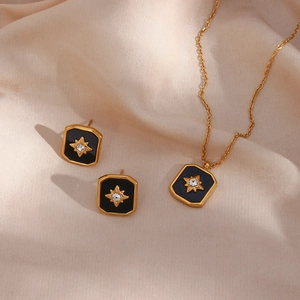 Detailed close-up of golden starburst necklace and earrings set on beige silk fabric