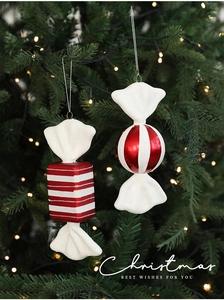 Macro detail of red and white striped candy ornaments hanging on a lighted Christmas tree