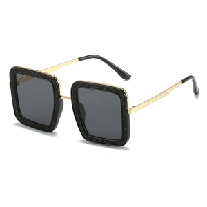 Moderne vierkante zwarte glitter zonnebril met gouden metalen pootjes op wit