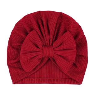 Detailed texture of burgundy ribbed knit baby hat with a large decorative bow