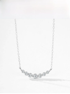 Macro detail of S925 silver necklace featuring seven radiant gradient diamonds in a smile shape