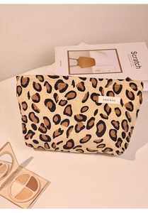 Detailed shot of leopard print corduroy makeup bag with H&R label and styling props