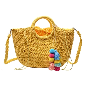 Bohemian yellow straw woven handbag with round handles and colorful tassel detail
