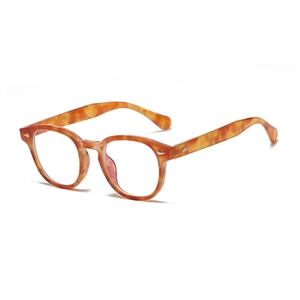 Lunettes rondes vintage écaillées avec clous en losange argentés sur fond blanc