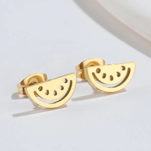 Close-up of golden hollowed-out watermelon stud earrings with minimalist metal details