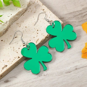 Details von grünen Acryl-Kleeblatt-Ohrringen auf Stein für St. Patrick's Day Partys