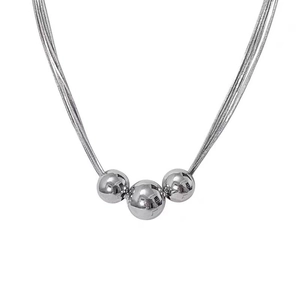 Layered gold titanium steel necklace featuring polished round beads on a triple chain design