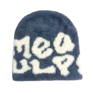 Détails de la texture douce en fausse fourrure et des motifs tricotés du bonnet bleu