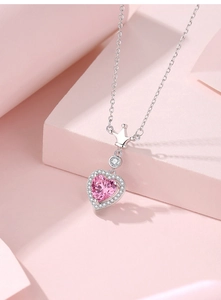 Detailed view of pink heart pendant with silver crown accent and sparkling zircon