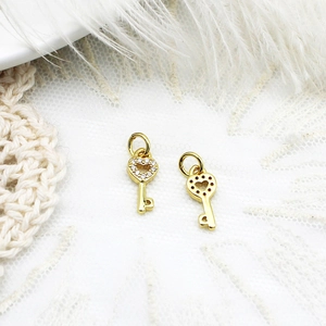 Detailed view of gold mini key pendants with micro-pave rhinestones and heart cutouts