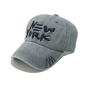 Detail of grey corduroy baseball cap with blue NEW YORK embroidery and brim stitching