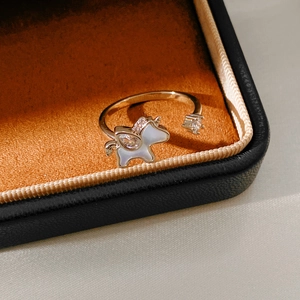 Detail of a gold unicorn ring with zircon and shell pearls in a premium jewelry box