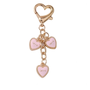 Golden heart keychain with three pink enamel charms featuring Love engraving on white background