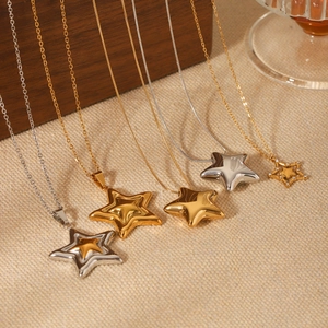Close-up of assorted stainless steel star pendant necklaces in gold and silver finishes