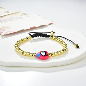 Handmade beaded heart bracelet with evil eye charm on a stylish ceramic display tray