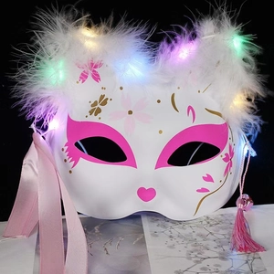 Detail of LED fox mask with white feathers, pink cherry blossoms and glowing lights