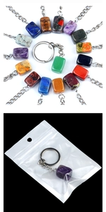Macro detail of colorful irregular stone keychains with metal rings and PE bag packaging