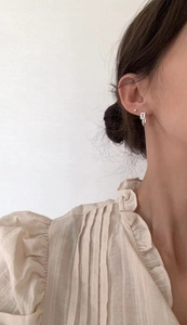 Minimalist silver square zirconia stud earring worn by a model in a side view close-up