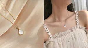 Detailed macro view of the gold fan-shaped necklace with white mother of pearl inlay