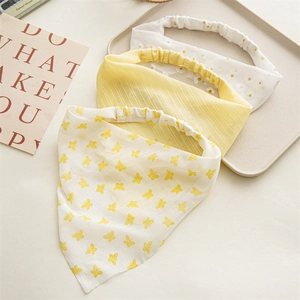 Detail of floral chiffon hair scrunchies with daisy embroidery and butterfly patterns