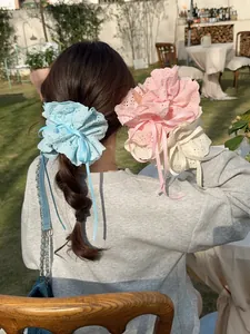 Detailed embroidery on light blue, pink, and beige lace scrunchies with elegant ribbons