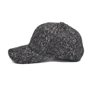 Close-up of thick grey tweed baseball cap with textured knit fabric and curved brim