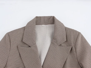 Dettaglio del rever pied-de-poule marrone e etichetta taglia S sul lungo cappotto blazer