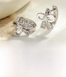 Macro detail of silver bow tie hoop earrings with zircon pavé and inner diameter info