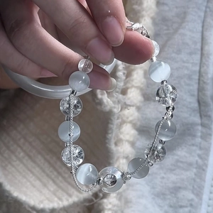 Faux crystal beaded heart bracelet with moon pendant shown on hand against grey background