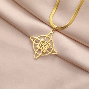 Détail du collier chaîne serpent dorée avec pendentif rose sur satin champagne