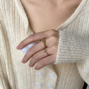 Gold ring set with oval green gemstone and zircon star design on model hand