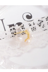 Détail de boucles d'oreilles en argent S925 dorées en C avec cinq perles blanches