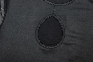 Close-up of teardrop-shaped cutout on black long sleeve dress with mesh stitching
