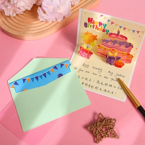 3D pop-up birthday card with cake design, green envelope on a pink background