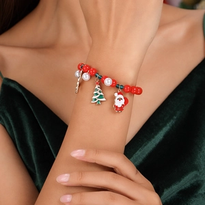 Close-up of Christmas beaded bracelet with Santa Claus and tree charms on model's wrist