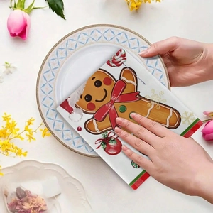 Gingerbread man patterned kitchen towel with Christmas decorations placed on a plate