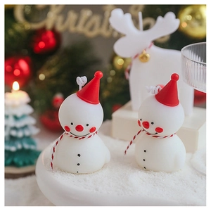 Vue détaillée de bougies parfumées bonhomme de neige avec bonnets rouges pour Noël