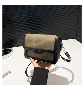 Detail of army green and black patchwork square bag with metal clasp and thin strap
