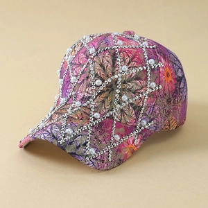 Close-up detail of mesh rhinestones and white pearls on floral print baseball cap