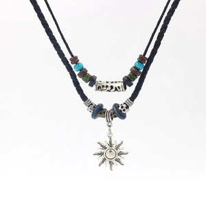 Close-up of woven leather sun pendant necklace with ethnic wood beads and metal accents