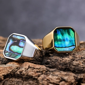 Detailed view of silver and gold stainless steel rings with iridescent abalone shell inlay